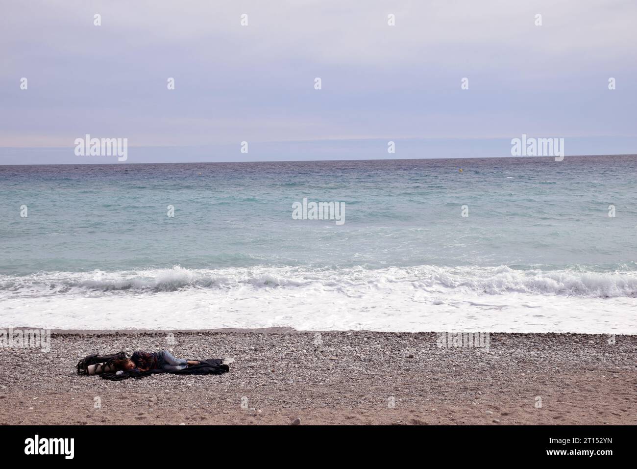 Senzatetto che dorme sulla spiaggia, Mentone, Cote D'Azur, Francia settembre 2023 Foto Stock