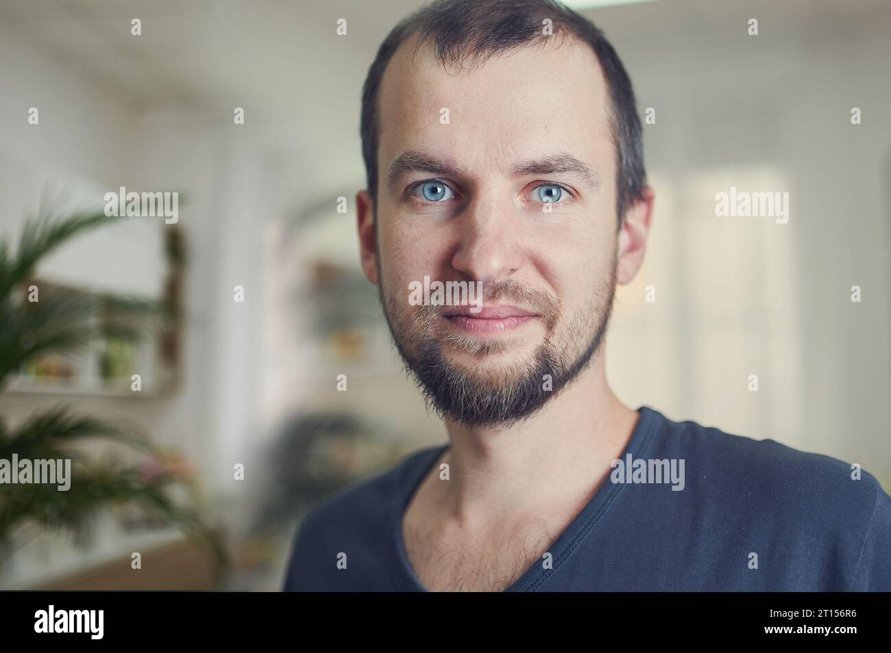 Ritratto di bell'uomo di 35 anni a casa. Sfondo blu Foto Stock