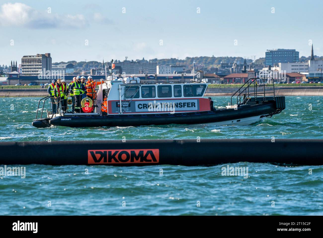 Personale su una barca di supporto che osserva un boom oceanico pesante schierato durante un esercizio di addestramento nazionale contro l'inquinamento presso il porto di Aberdeen per la lotta all'inquinamento (MCA). Data foto: Mercoledì 11 ottobre 2023. Foto Stock