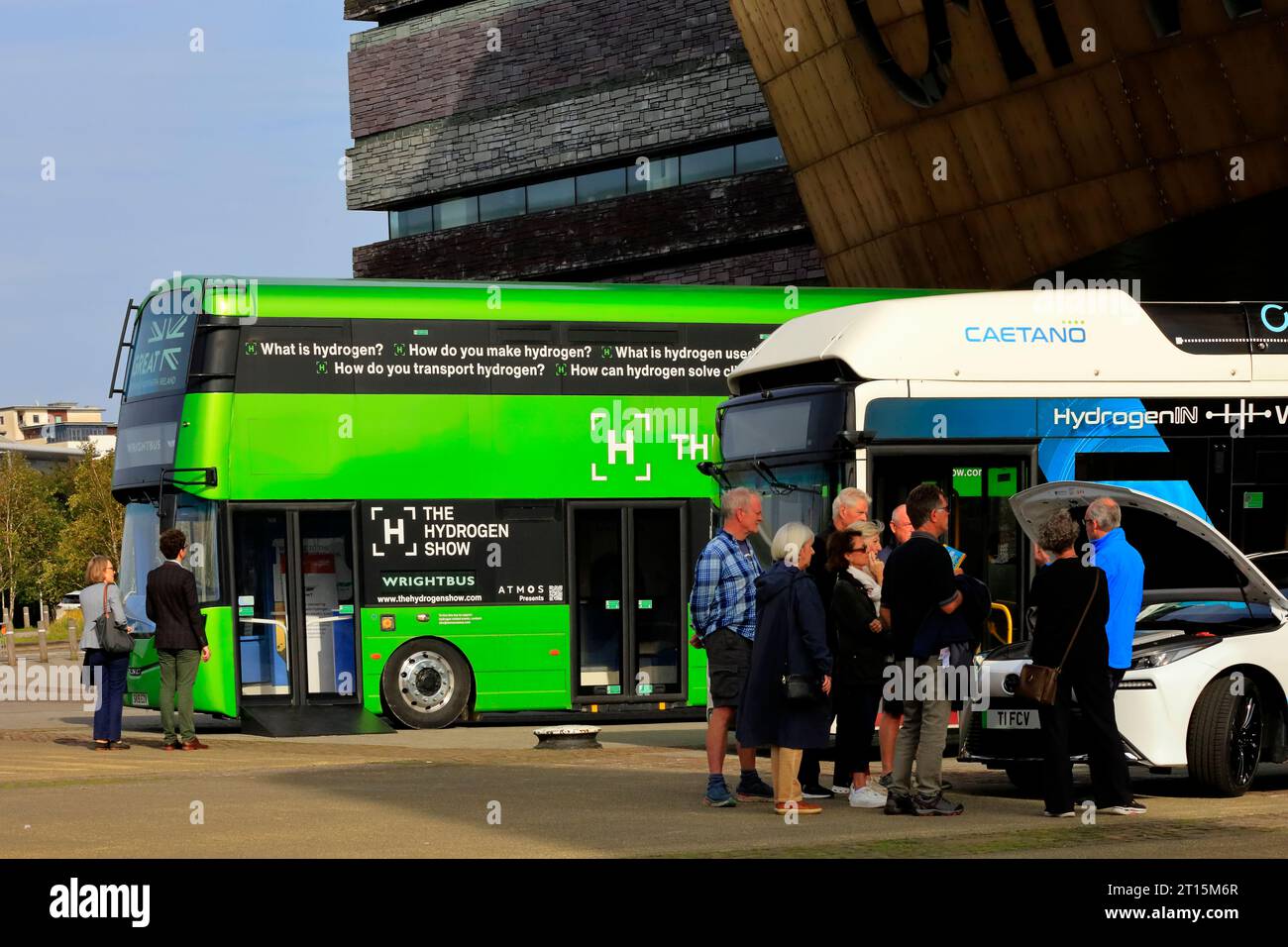 Autobus e automobili in un evento per la promozione di veicoli alimentati a idrogeno a zero emissioni al di fuori del Millennium Centre, Cardiff Bay. Ottobre 2023. Foto Stock