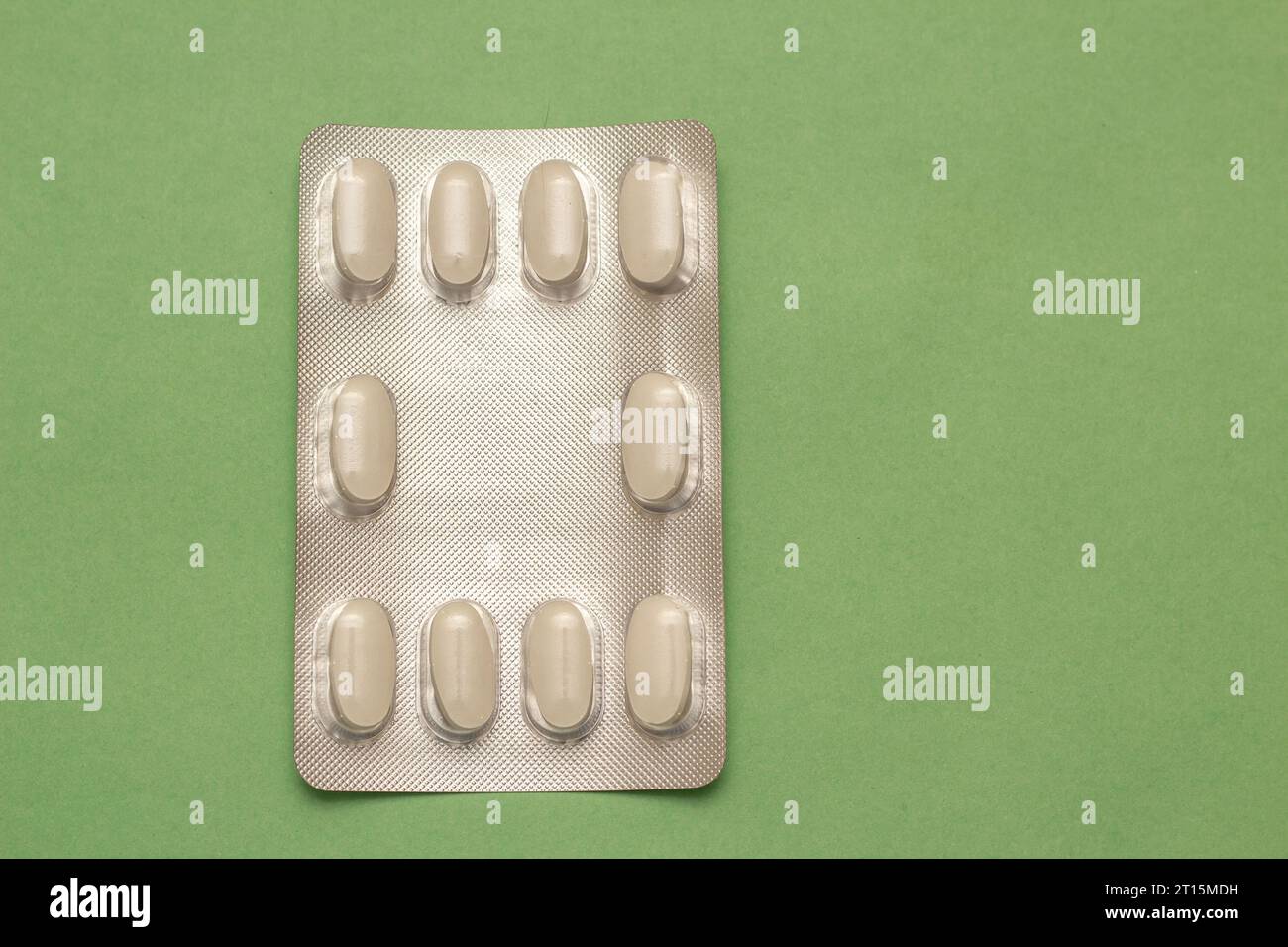 Goiânia, Goias, Brasile – 10 ottobre 2023: Un blister di plastica e alluminio con compresse su una superficie verde. Foto Stock