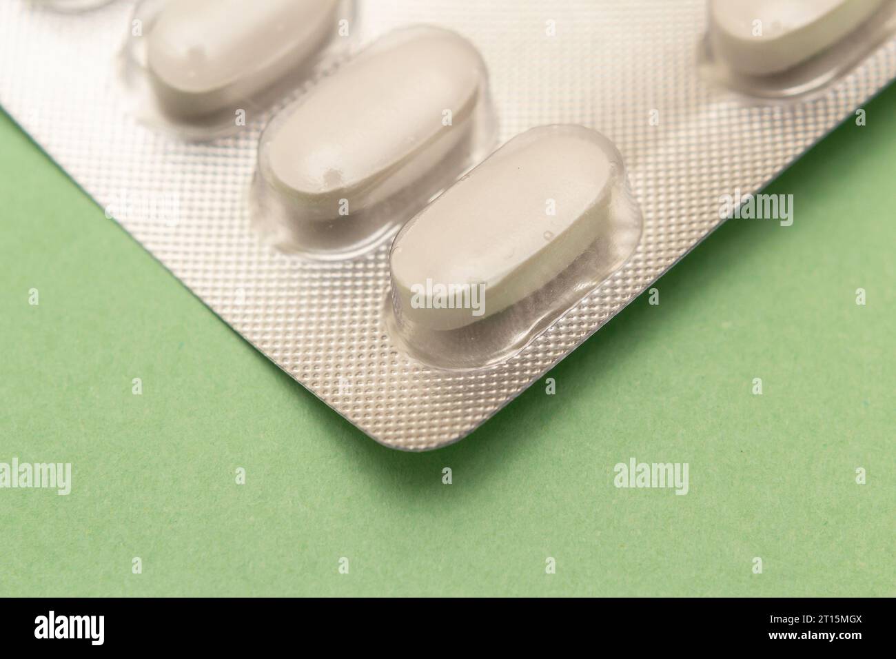 Goiânia, Goias, Brasile – 10 ottobre 2023: Un blister di plastica e alluminio con compresse su una superficie verde. Foto Stock