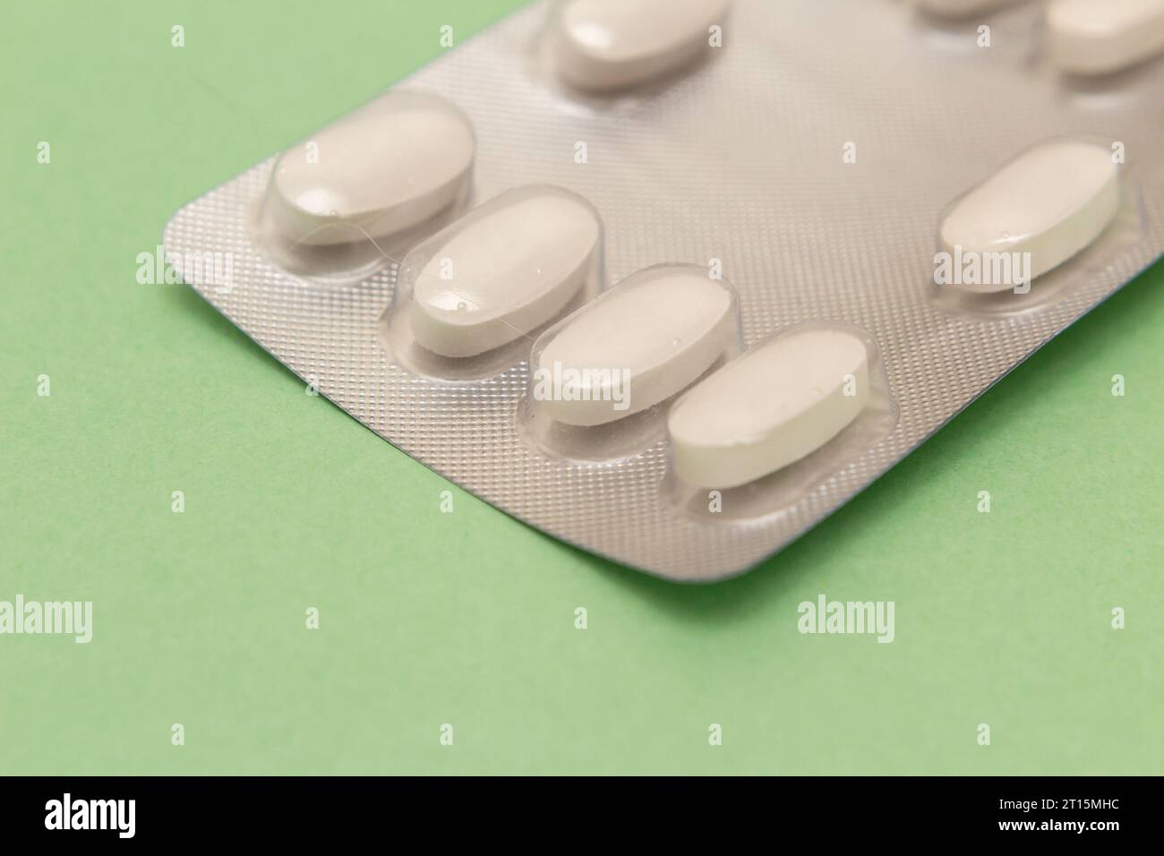 Goiânia, Goias, Brasile – 10 ottobre 2023: Un blister di plastica e alluminio con compresse su una superficie verde. Foto Stock