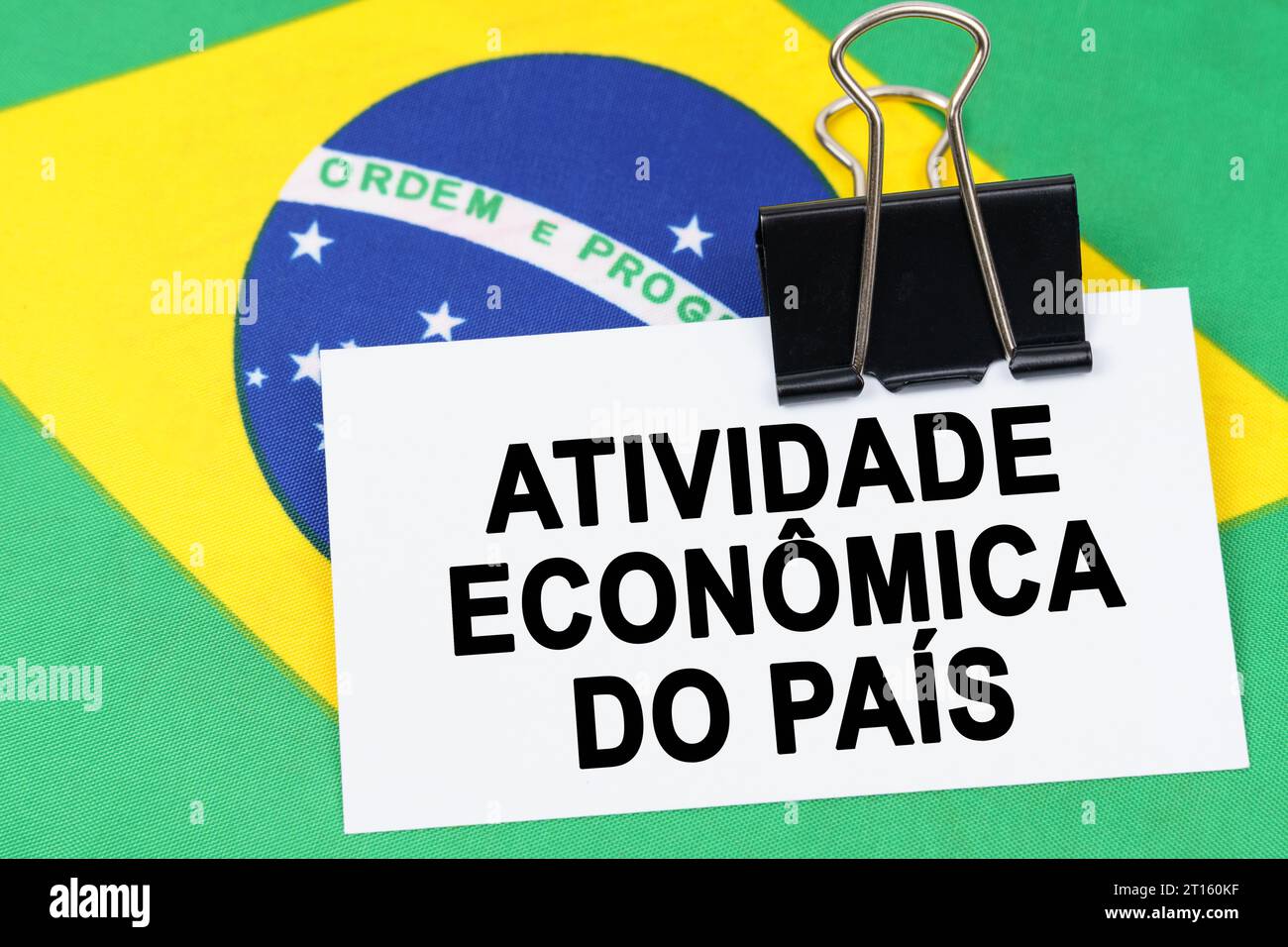 Economia e finanza. Sulla bandiera del Brasile si trova un biglietto da visita con l'iscrizione - attività economica del paese. Testo in portoghese. Foto Stock