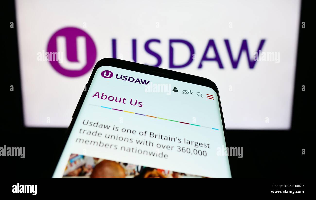 Smartphone con pagina Web di Union of Shop distributive and Allied Workers (USDAW) davanti al logo aziendale. Mettere a fuoco in alto a sinistra sul display del telefono. Foto Stock