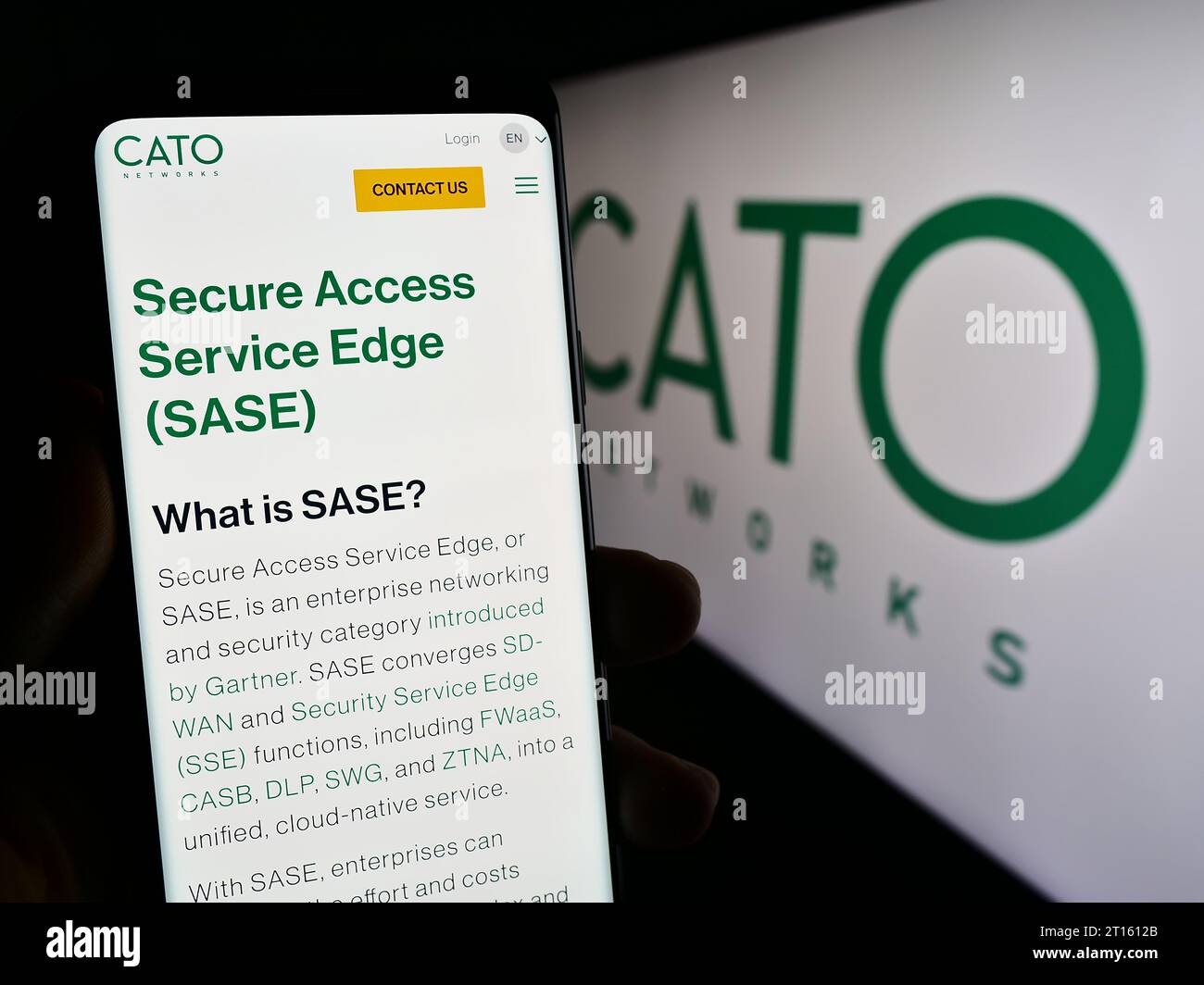 Persona che possiede uno smartphone con una pagina Web della società israeliana di sicurezza di rete Cato Networks Ltd. Davanti al logo. Concentrarsi sul centro del display del telefono. Foto Stock