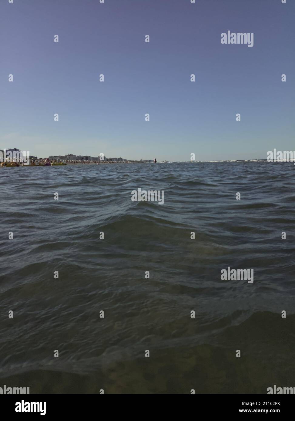 Litorale di una città italiana al tramonto in una giornata limpida vista da lontano sul mare Foto Stock