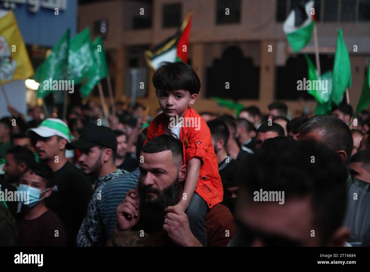 I palestinesi sventolano bandiere nazionali e Hamas gridano slogan durante la manifestazione per sostenere i movimenti di Hamas i palestinesi sventolano bandiere nazionali e Hamas gridano slogan durante la manifestazione per sostenere i movimenti di Hamas e la resistenza palestinese, l'11 ottobre 2023 a Hebron. Diversi palestinesi sono stati uccisi in scontri con le forze israeliane nella Cisgiordania occupata dall'inizio dell'offensiva di Hamas da Gaza contro Israele il 7 ottobre, con il movimento islamico che invita i combattenti della resistenza in tutti i territori palestinesi e nelle nazioni arabe e islamiche ad unirsi alla sua operazione alluvione al-Aqsa . Foto di Mamoun Wazwa Foto Stock