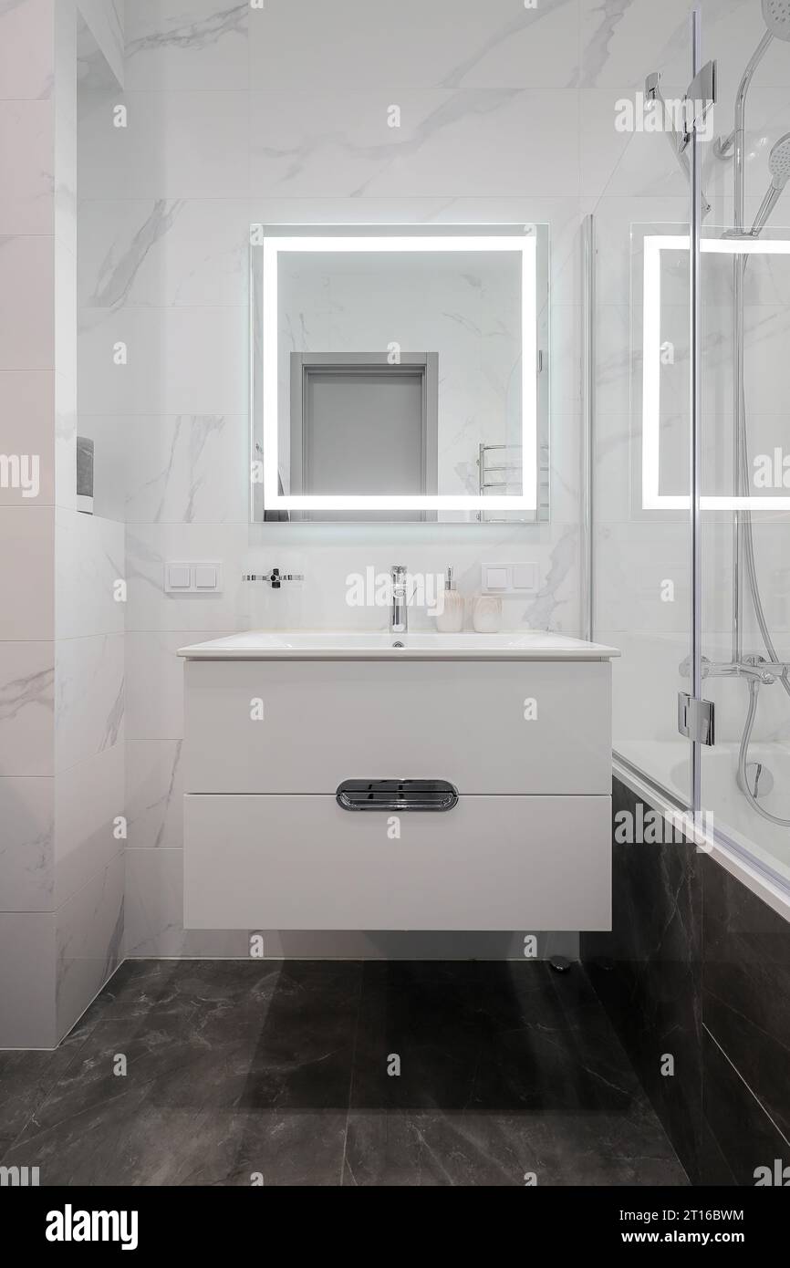 Rubinetto con lavabo in ceramica e specchio all'interno del bagno Foto Stock Rubinetto con lavabo in ceramica e specchio all'interno del bagno Foto Stock