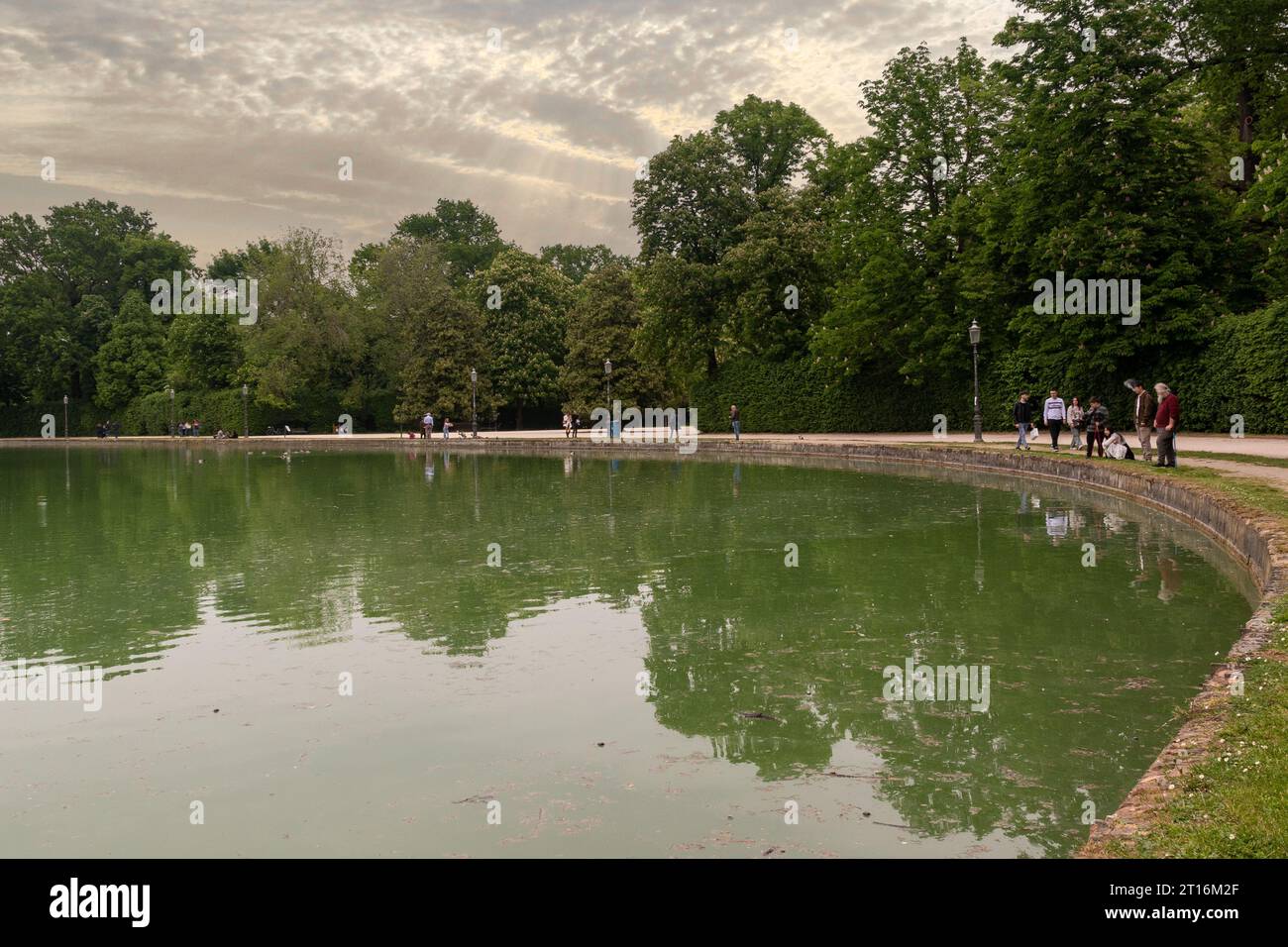 Lo stagno ("peschiera") del Parco Ducale con gente al tramonto in primavera, Parma, Emilia-Romagna, Italia Foto Stock