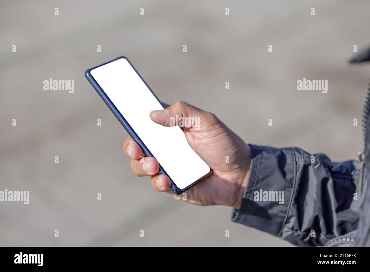 Dettaglio della mano di un uomo latino che tiene un telefono cellulare con schermo vuoto. Foto Stock