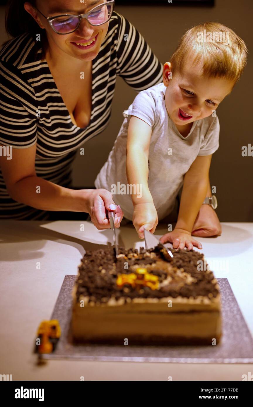 Madre e figlio di taglio torta di compleanno Foto Stock