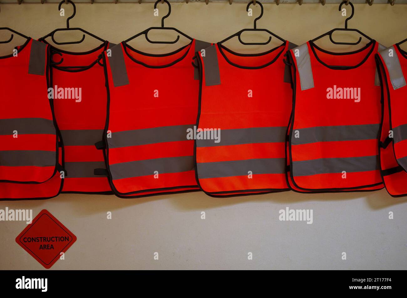 Diversi giubbotti riflettenti appesi al muro Foto Stock