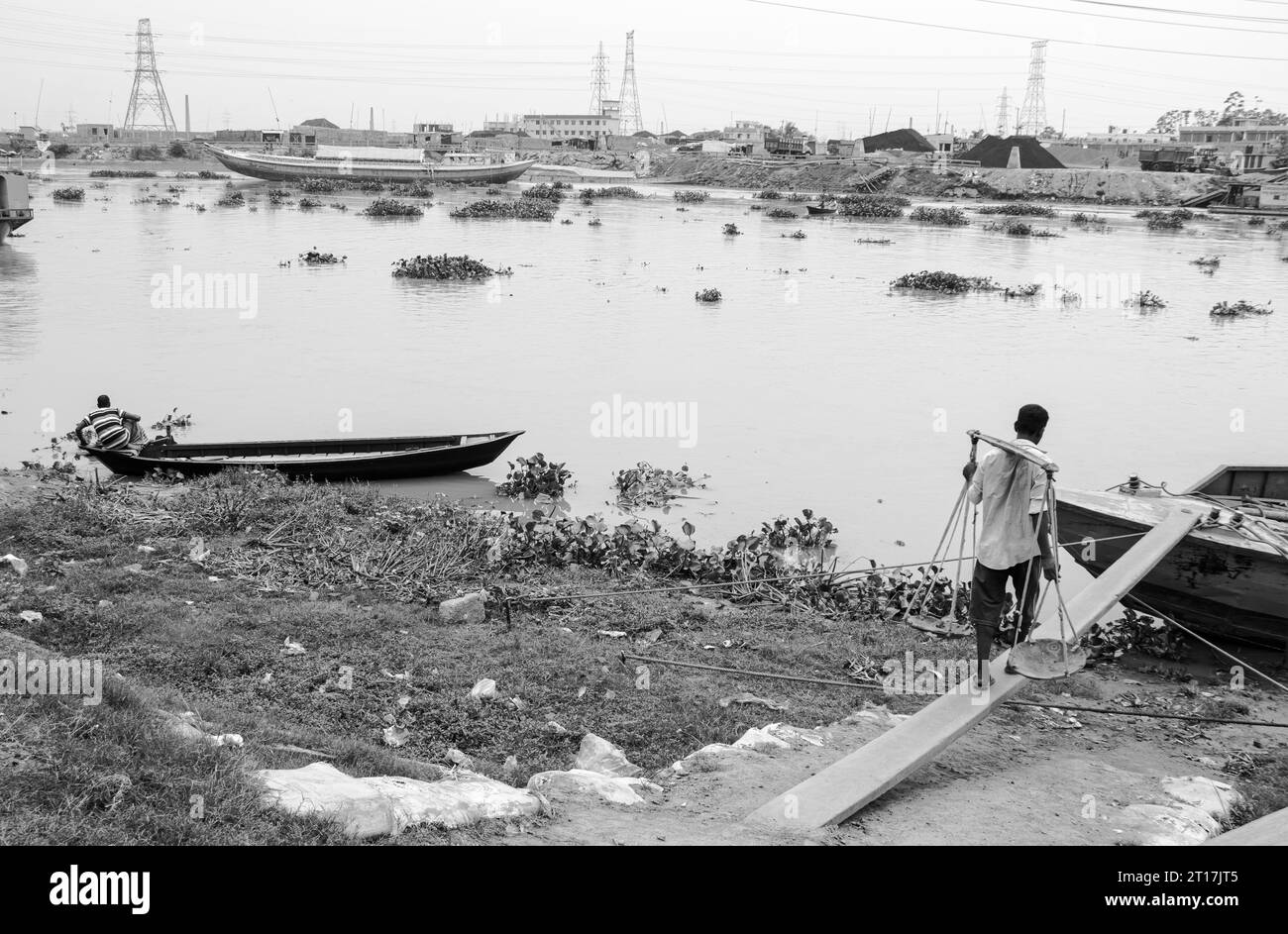 Persone che scaricano mattoni dalla barca, l'immagine scattata il 29 maggio 2022, da Amen Bazar, Bangladesh, dove i lavoratori sono impegnati a scaricare mattoni pesanti Foto Stock