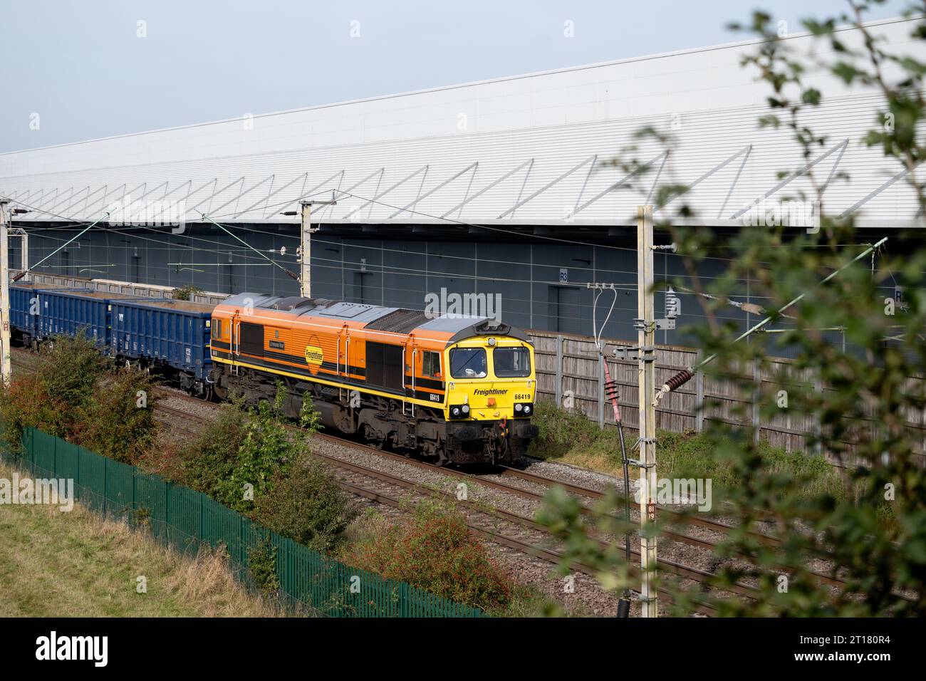 Locomotiva diesel Freightliner classe 66 n. 66419 «Lionesses» Roar» che tira un treno merci oltre DIRFT, Northamptonshire, Inghilterra, Regno Unito Foto Stock