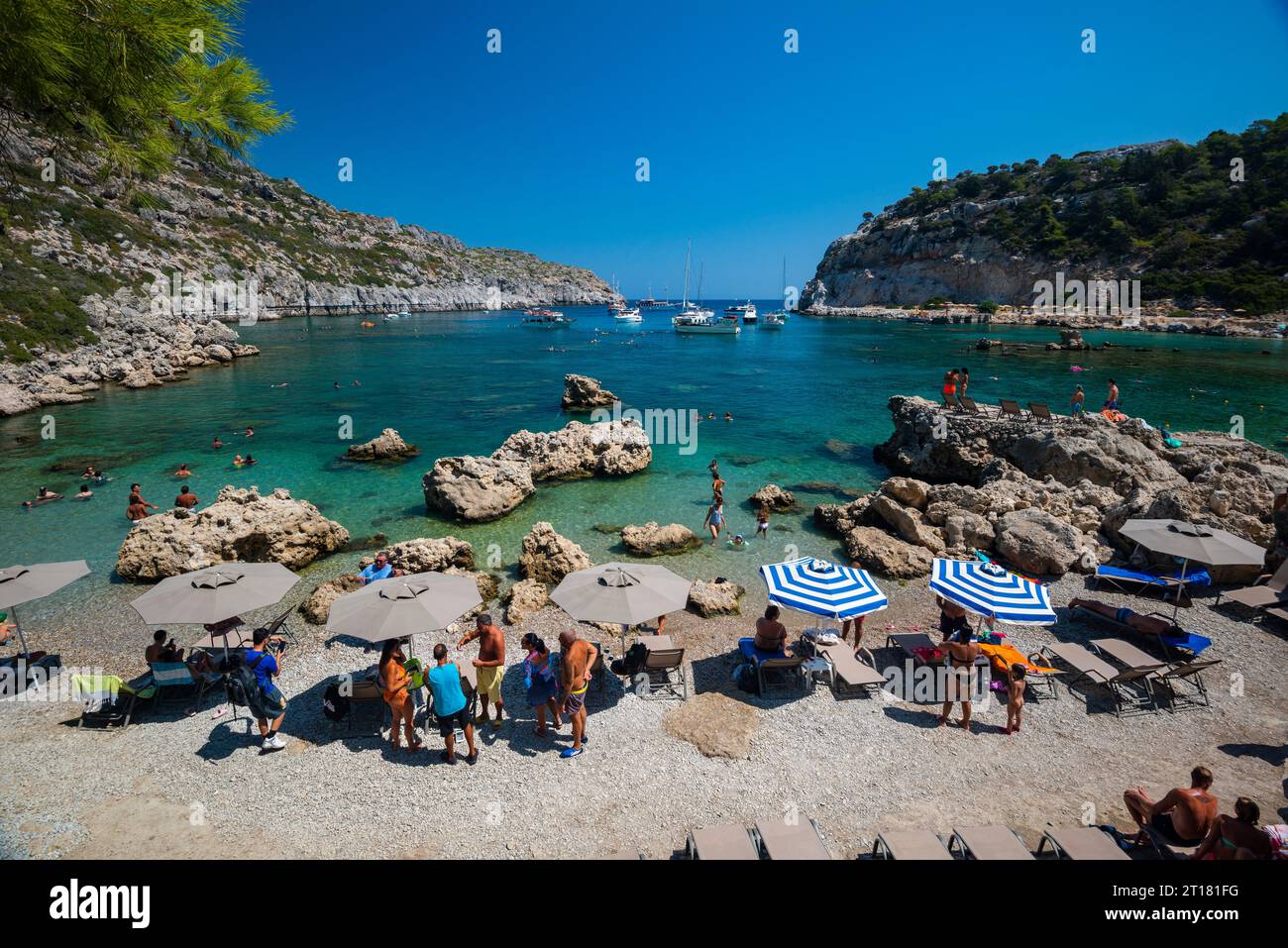 Sonnenschirme und Liegen am Strand, türkisblaues Wasser, Anthony Quinn Bucht, Faliraki, Rhodos, Dodekanes, Griechenland Foto Stock