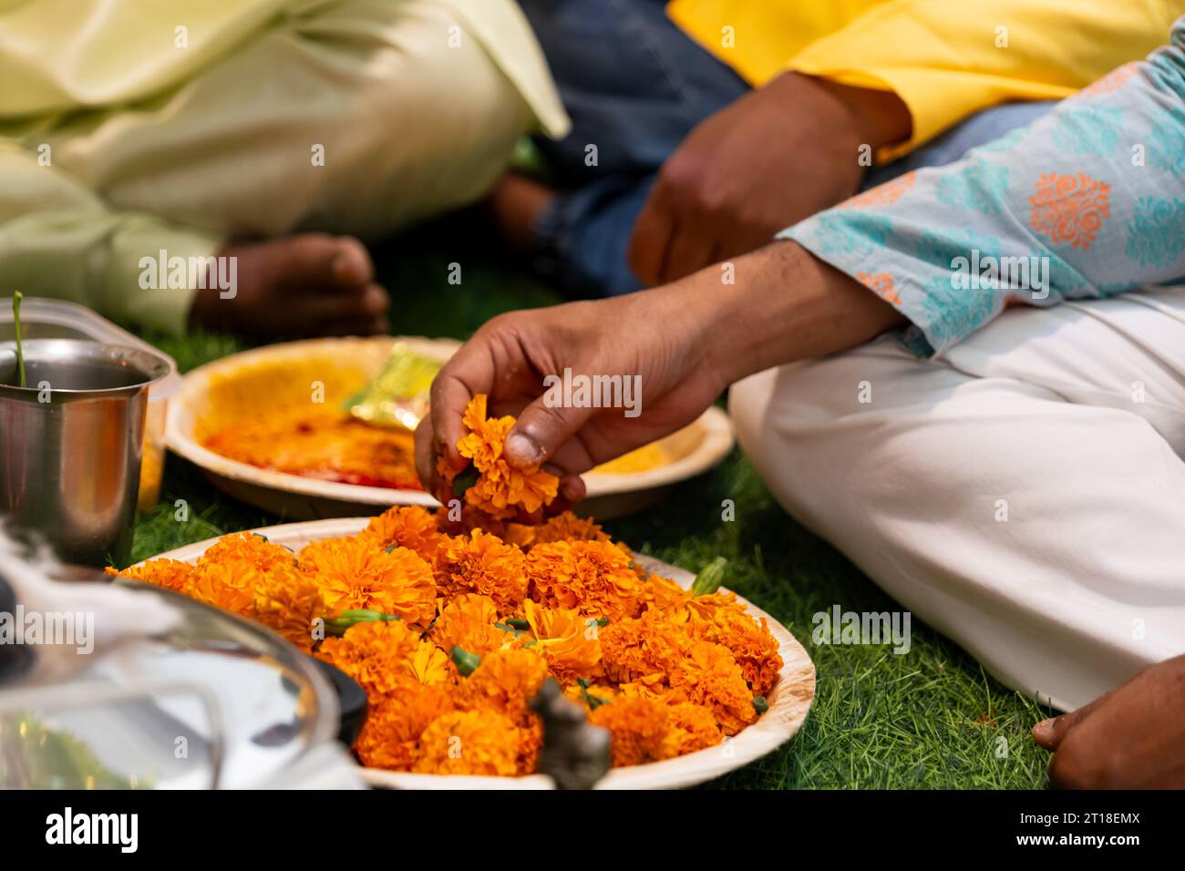 Un uomo che prega con un fiore d'arancio in mano Foto Stock