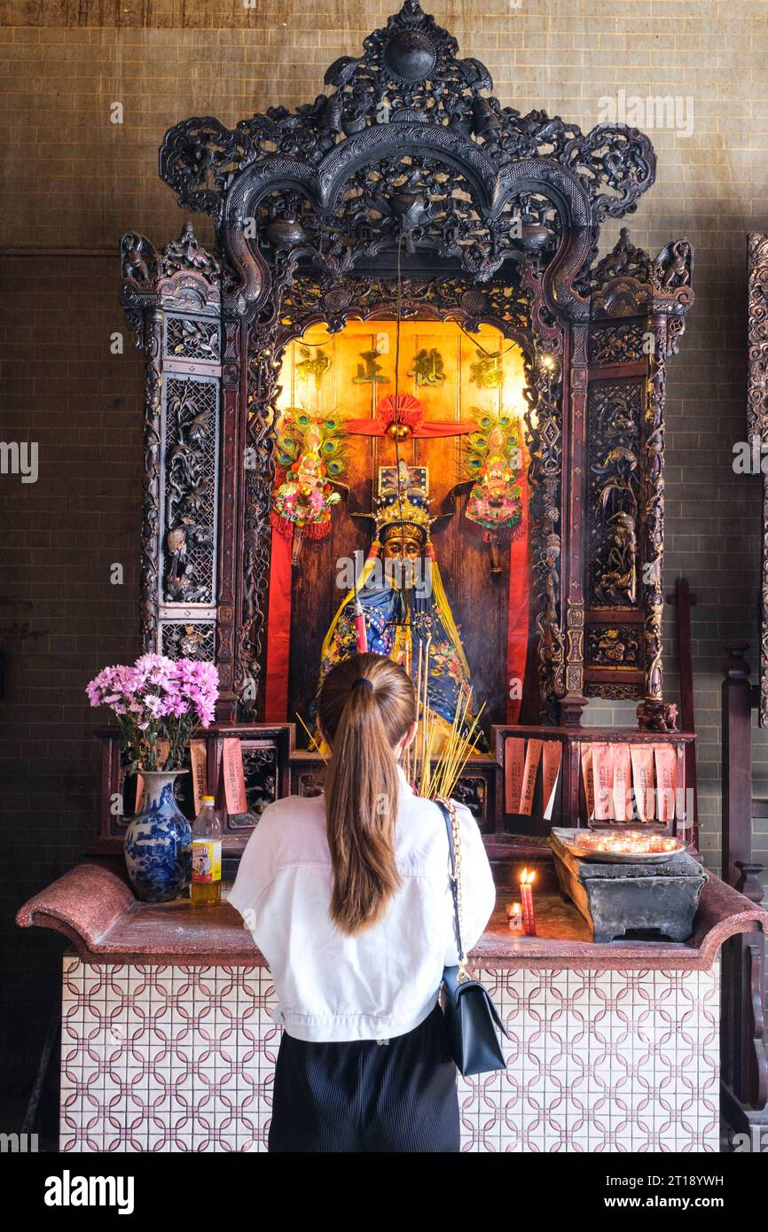 Adoratore che prega di fronte all'altare Mon Quan Vuong, alla pagoda Thien Hau, alla città di ho chi Minh, Vietnam. Foto Stock