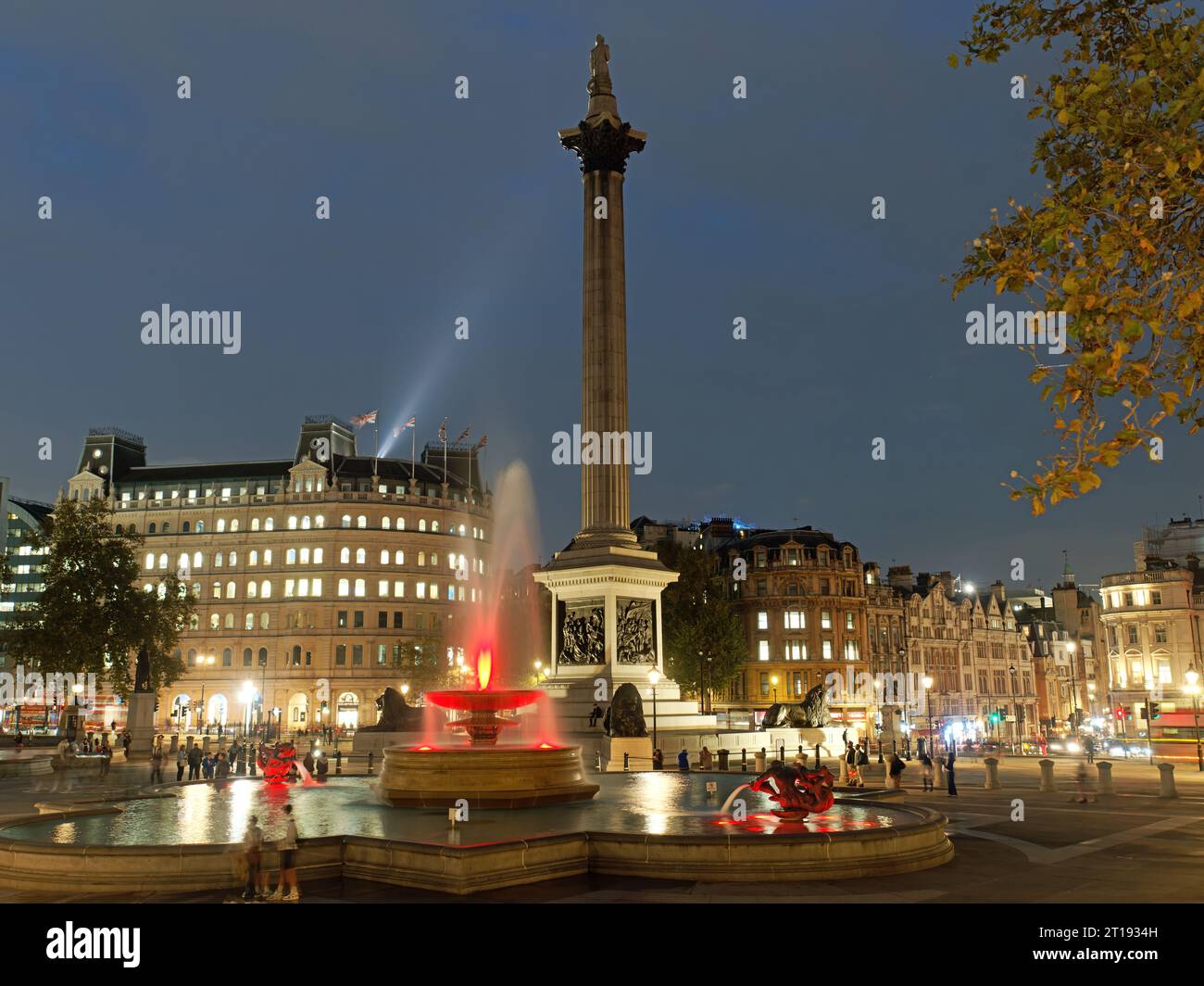 Vista della colorata Trafalgar Square e della colonna di Nelson illuminata di notte Foto Stock