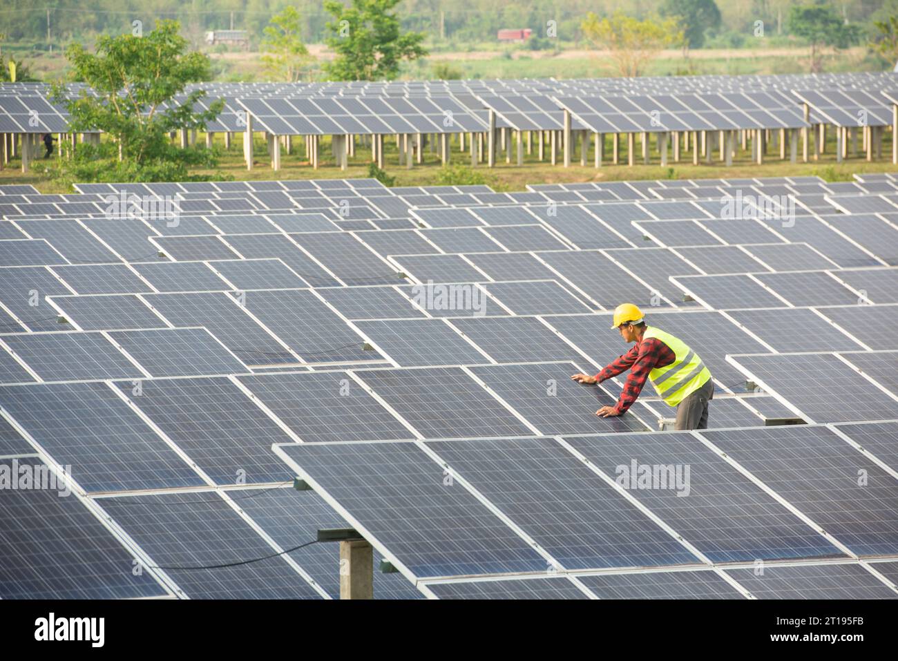 Ritratto di un ingegnere che lavora su pannelli solari in una stazione a energia solare, Thailandia Foto Stock