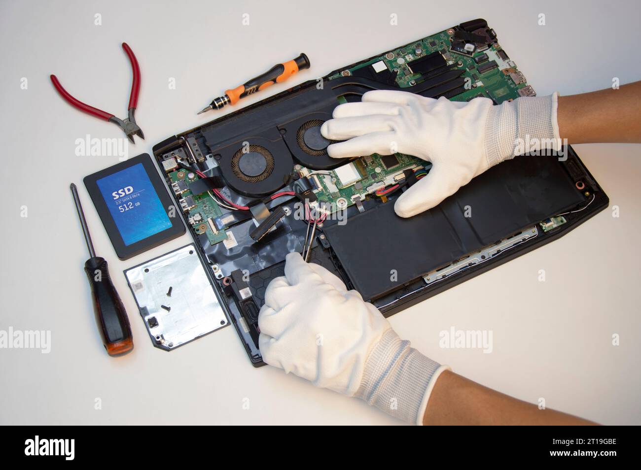 Vista dall'alto. Tecnico che ripara il notebook, ripara la scheda madre e il circuito. Foto Stock