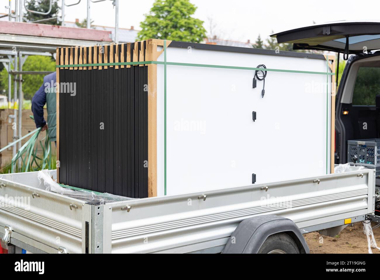 Un set di nuovi pannelli solari trasportati su un rimorchio a un cantiere edile Foto Stock