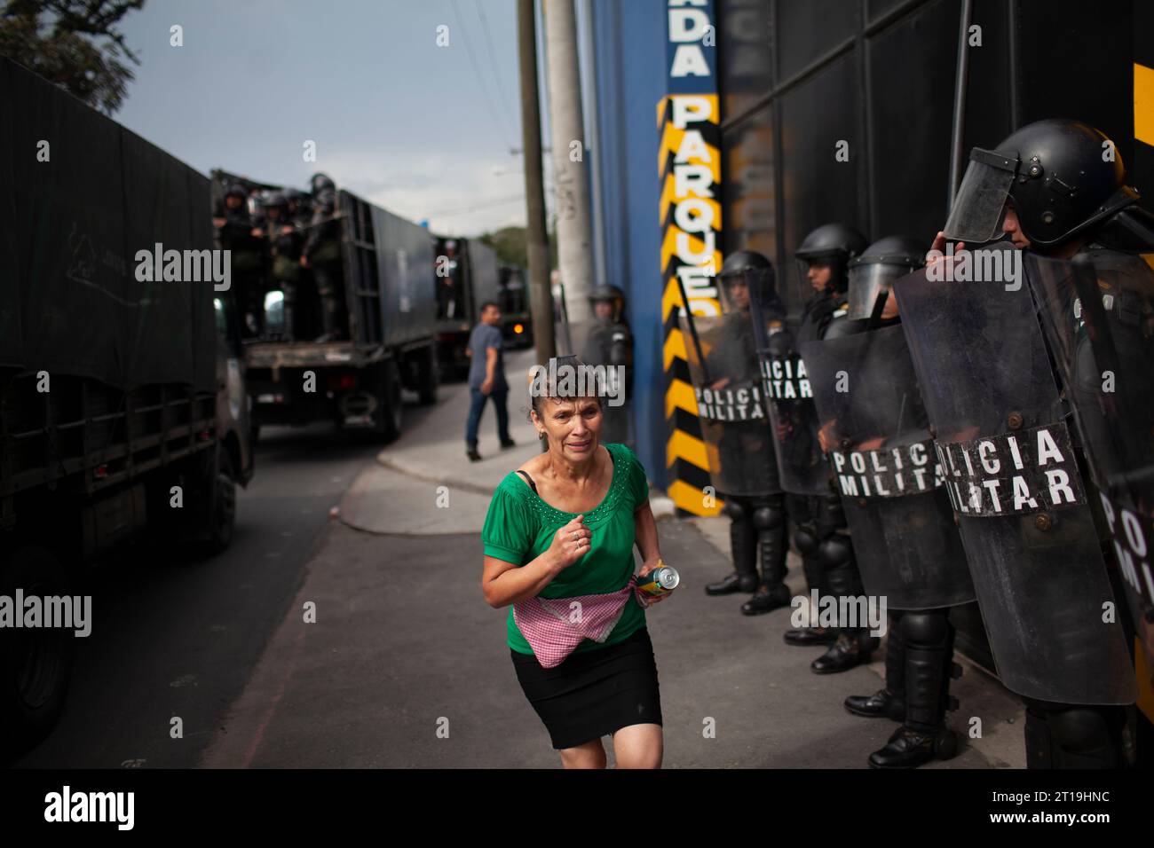 Guatemala Stadt, Guatemala. 10 ottobre 2023. Una donna spaventata passa davanti agli agenti di polizia. I manifestanti bloccarono circa 125 strade nel paese centroamericano in segno di protesta contro le azioni dell'Ufficio del Procuratore generale contro il presidente eletto Arevalo. Credito: Sandra Sebastian/dpa/Alamy Live News Foto Stock