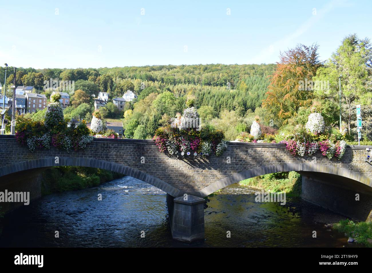 ponte in pietra ad arco doppio con fiori in fiore Foto Stock
