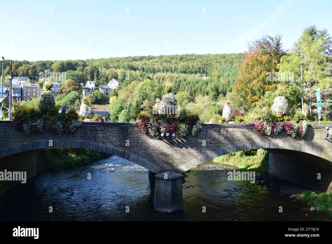 ponte in pietra ad arco doppio con fiori in fiore Foto Stock