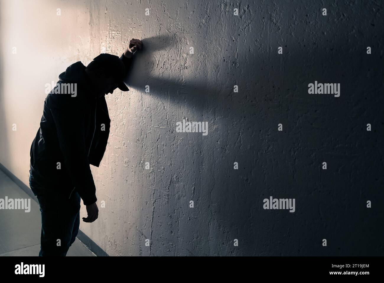 Ubriaco, ubriaco, uomo contro muro. Problema di alcol, tossicodipendenza o concetto di sovradosaggio. Nausea, vomito per strada. Giovane persona vertiginosa in un vicolo buio. Foto Stock