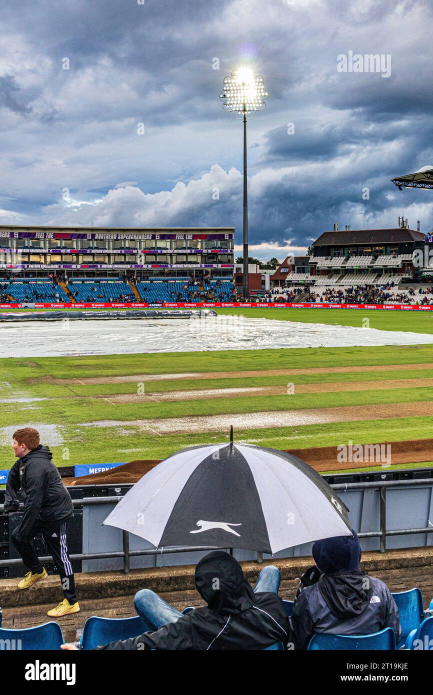 Le coperture sul campo e il campo di gioco calpestato dopo una torrenziale discesa piovono a causa di una partita T20 serale all'Headingley Cricket Ground a Leeds, Yorks. Foto Stock