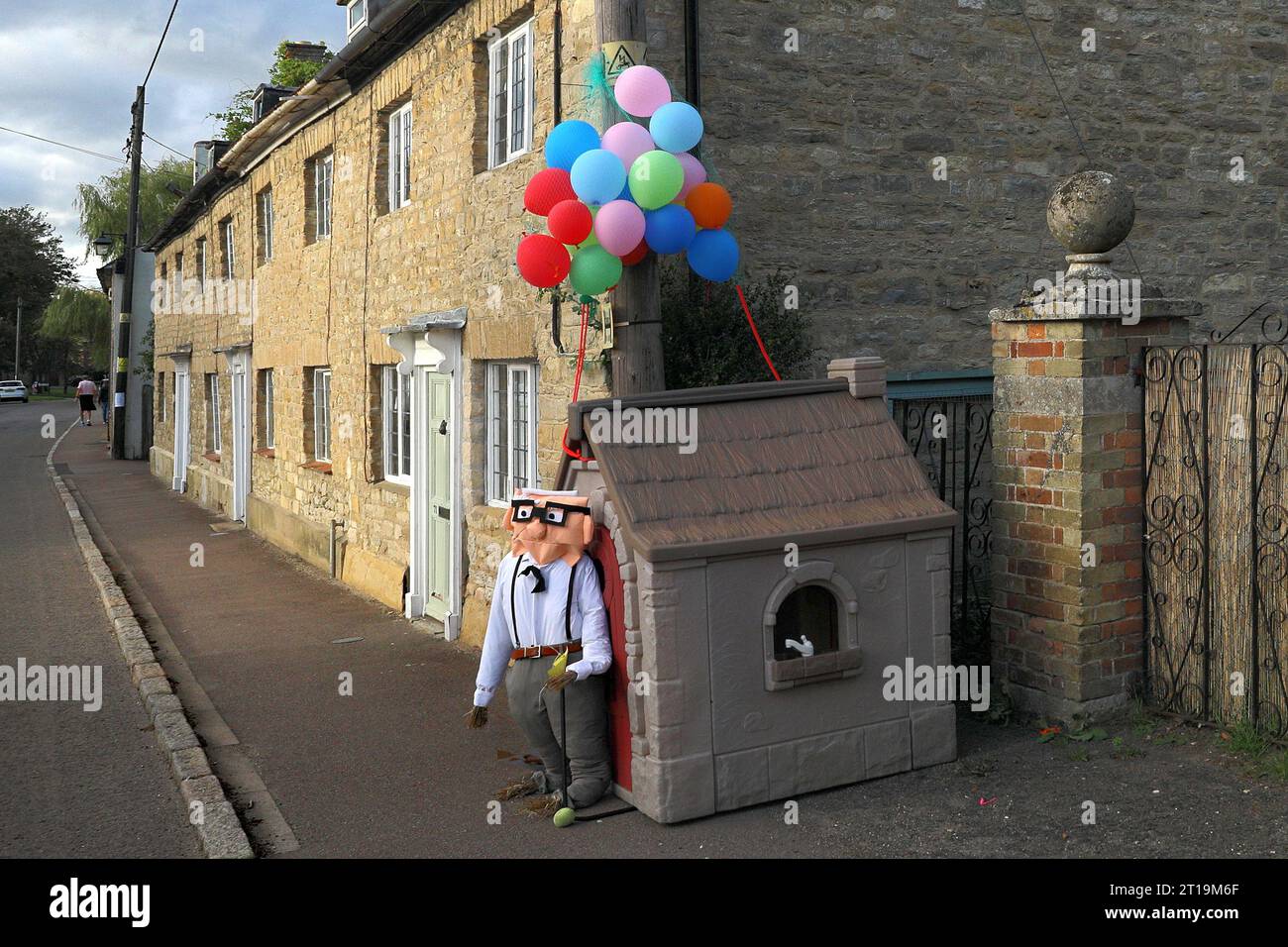 Carl Fredricksen e i personaggi scavati dalla scena della Flying House nel film Disney Up al festival dello spaventapasseri del villaggio a Sharnbrook, Bedfordshire, Inghilterra, Regno Unito Foto Stock