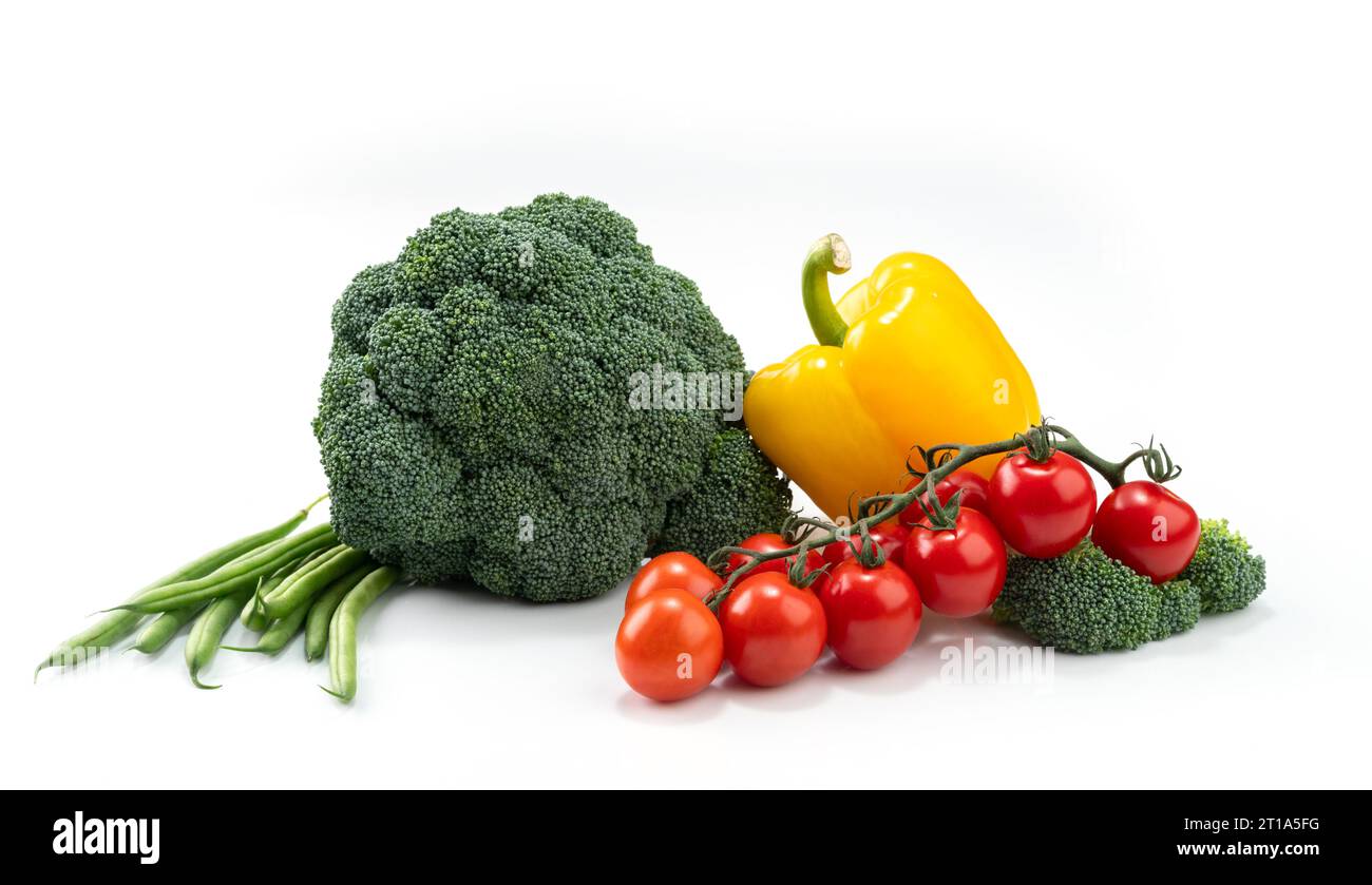 composizione di verdure su fondo bianco: broccoli, sottaceti verdi, pepe e pomodori ciliegini Foto Stock