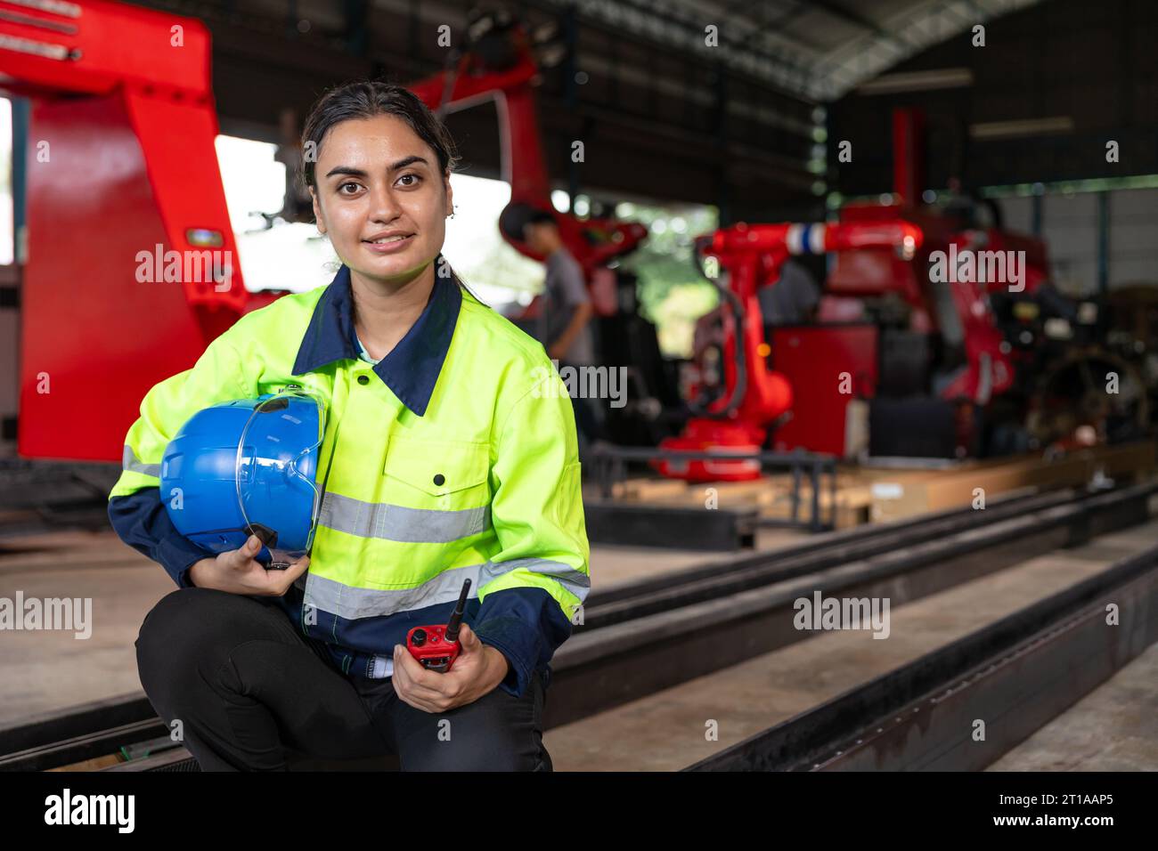 Ritratto intelligente signora indiana ingegnere donna supervisore che lavora indossa tuta di sicurezza riflettente lavoro nella fabbrica di macchinari robotizzati per metalli Foto Stock