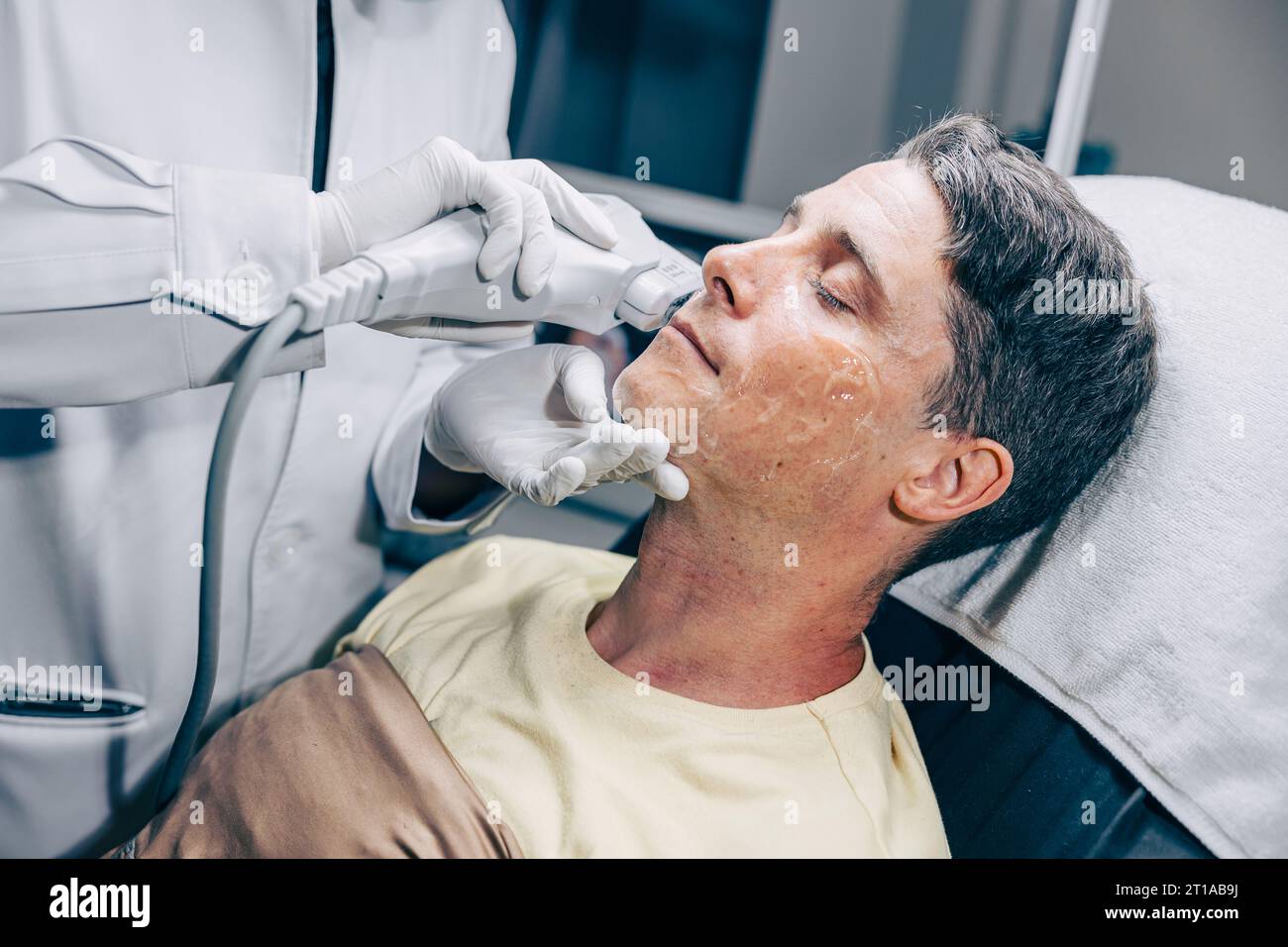 Medico della pelle che utilizza HIFU resurfacing facciale trattamento della pelle tecnologia con maschio adulto per ridurre rughe e cicatrici presso la clinica anti invecchiamento Foto Stock