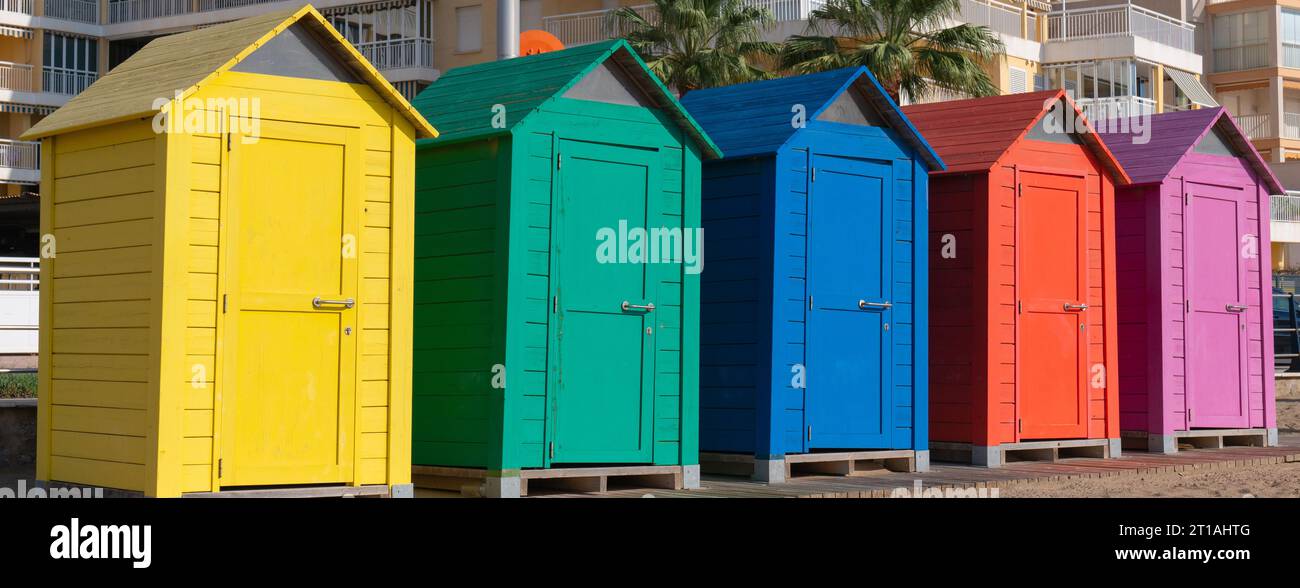 Colorate capanne sulla spiaggia in Spagna colori vivaci con arancio verde blu giallo viola Foto Stock