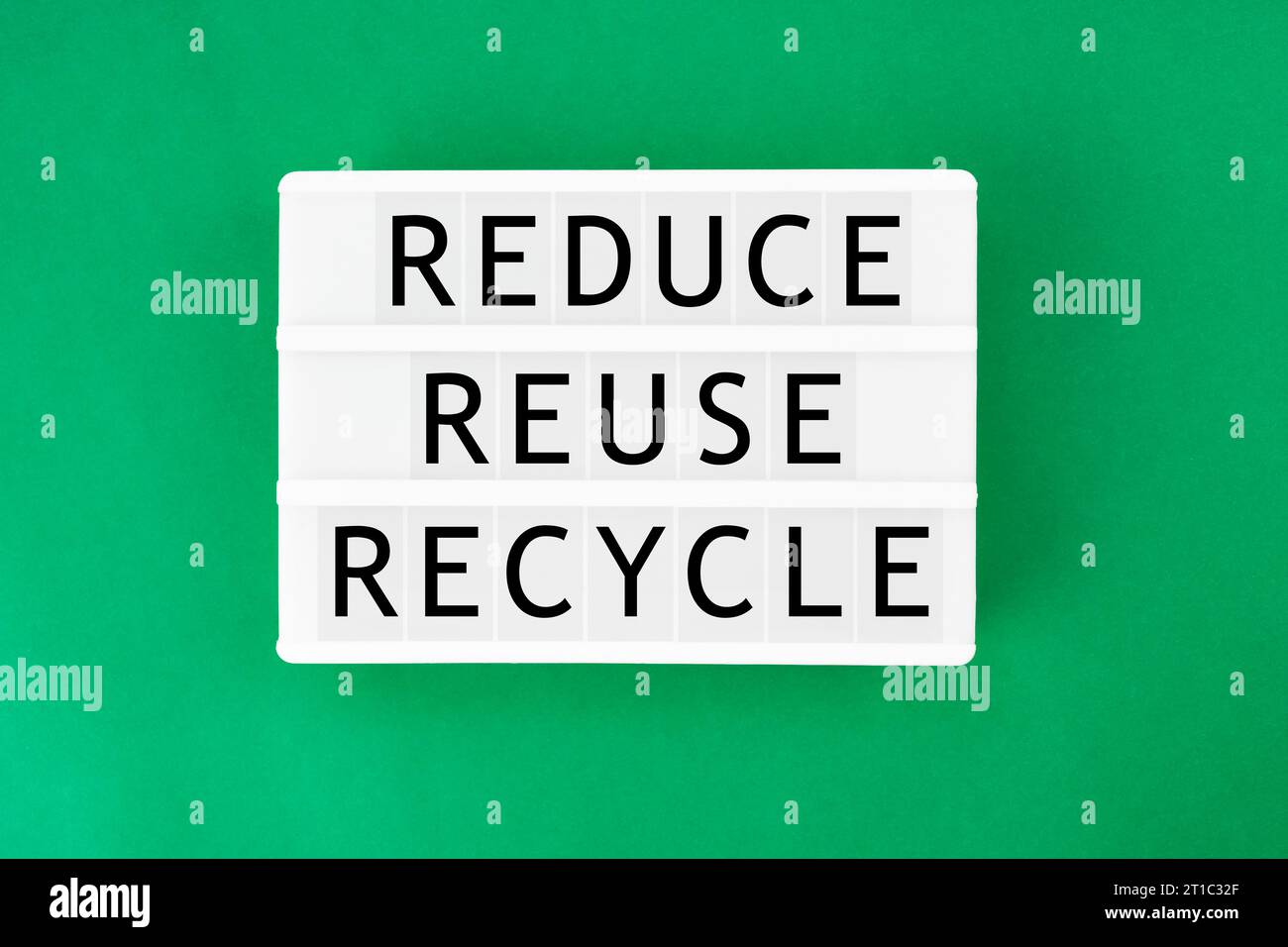 Scatola luminosa che visualizza il testo "Riduci riciclo riutilizzo" su sfondo di colore verde. Concetti ecologici. Foto Stock