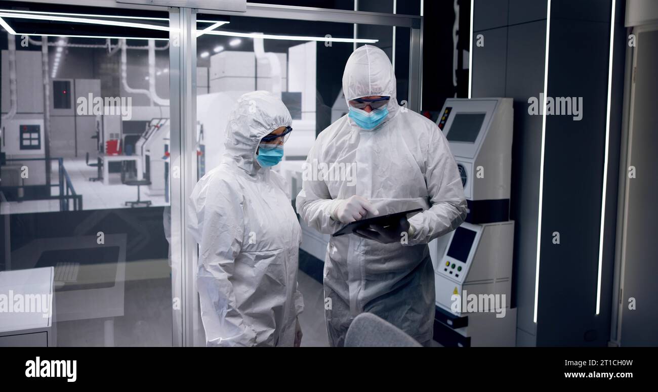 Fabbrica di produzione di semiconduttori sterile e lavoratori in tute Foto Stock