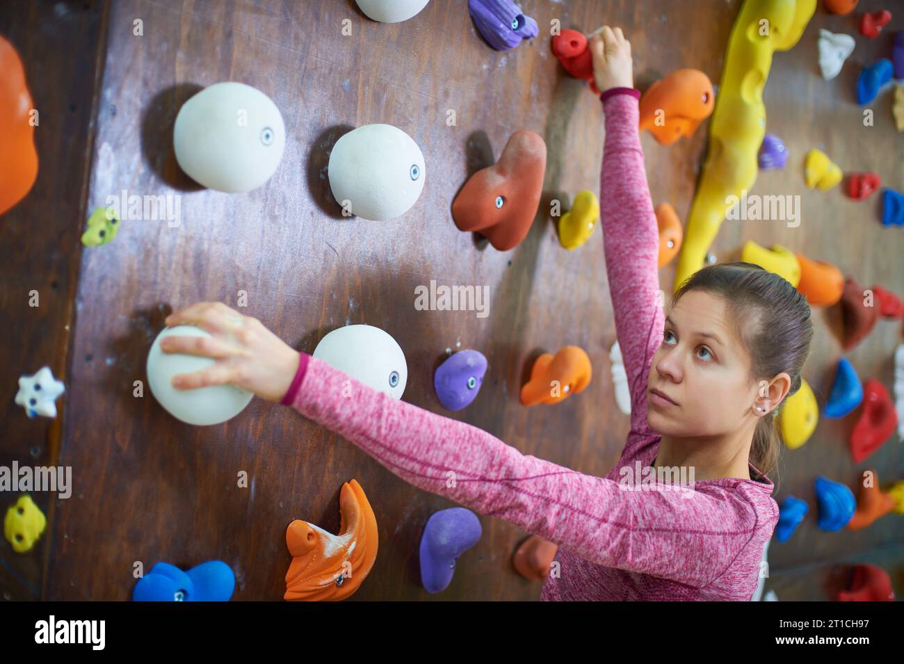 ritratto di una donna sportiva in una sala per arrampicata su massi Foto Stock