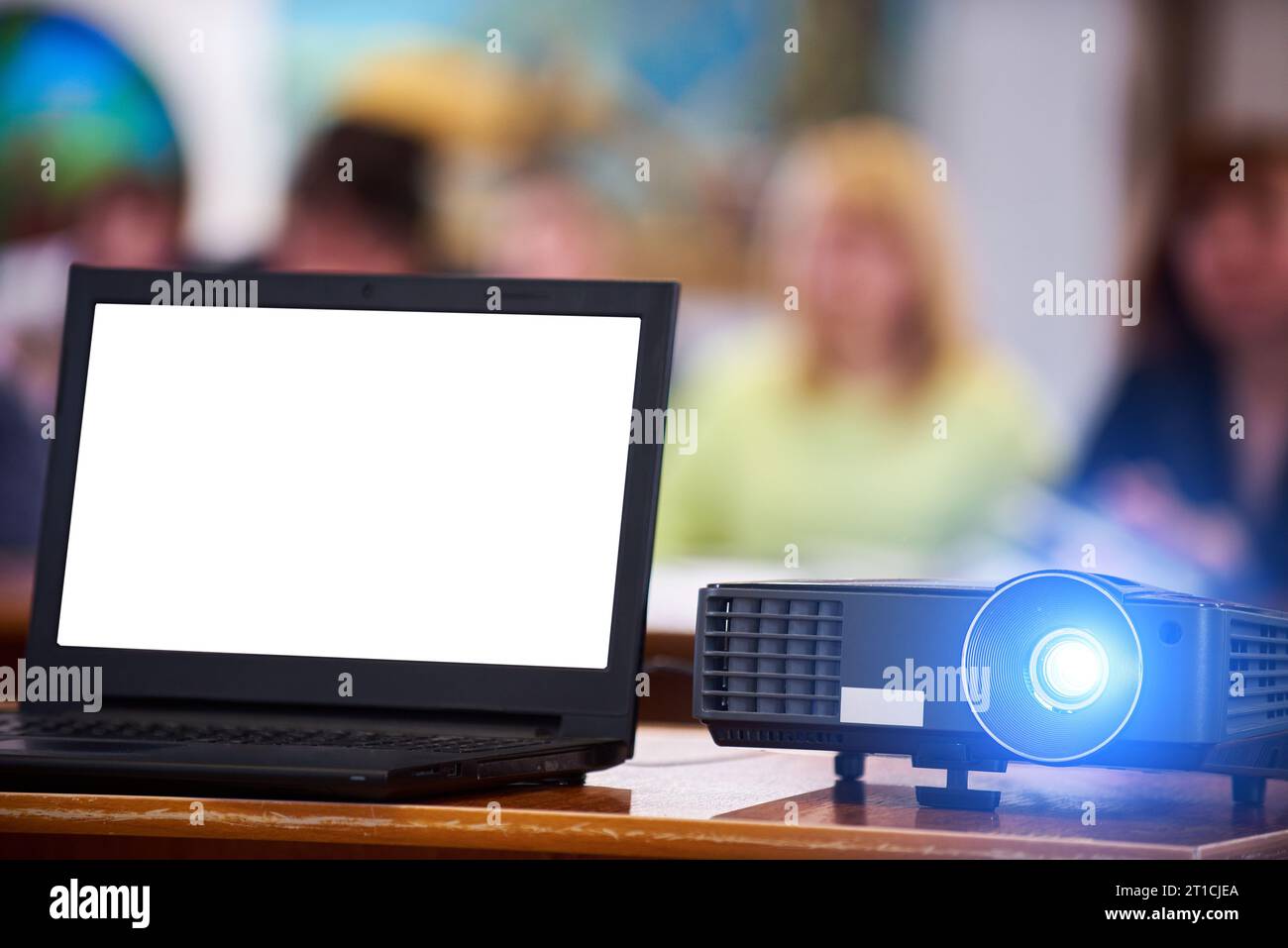 Proiettore funzionante nella sala conferenze. Notebook con schermo bianco. Persone sfocate sullo sfondo Foto Stock