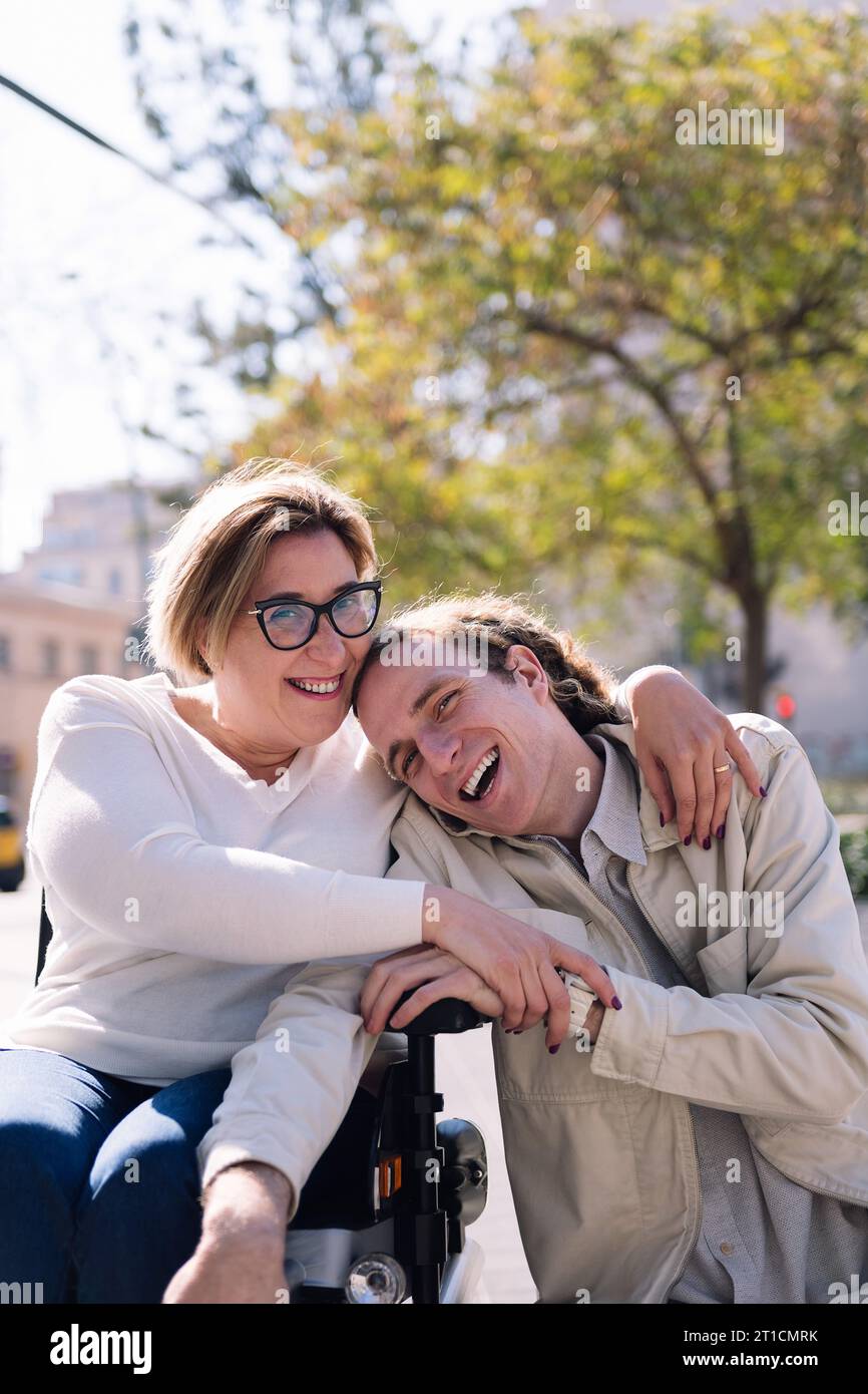 un paio di uomini e donne che usano la sedia a rotelle ridendo Foto Stock