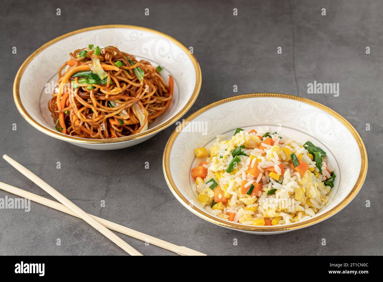 Tagliatelle con verdure e pilaf di riso con uova e mais in una ciotola bianca su sfondo scuro Foto Stock