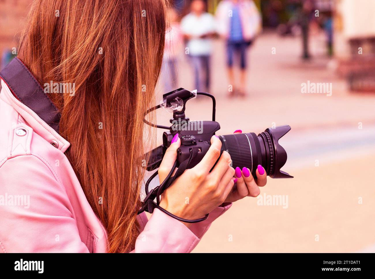 Cameraman con cuffie e videocamera HD. operatore femminile con la videocamera . fotografa la macchina fotografica per strada. Foto Stock