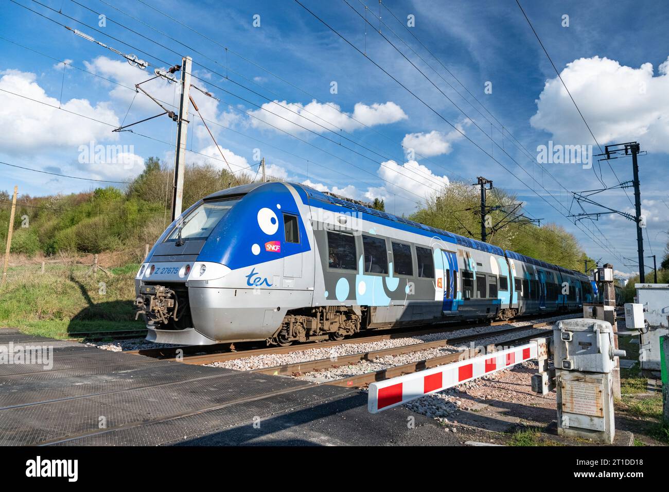 Passaggio di un treno ter attraverso un passaggio a livello, ferrovia che collega Parigi, Rouen e le Havre, a le Houlme (Normandia, Francia settentrionale) Foto Stock