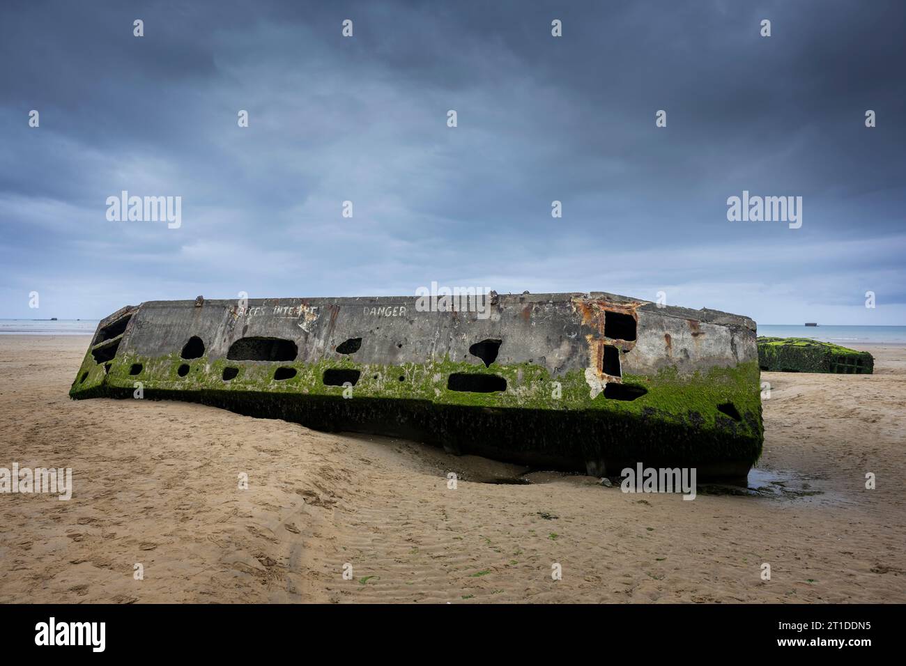 Resti di un Mulberry Harbour sulla spiaggia di Arromanches-les-Bains, Normandia, Francia. Foto Stock