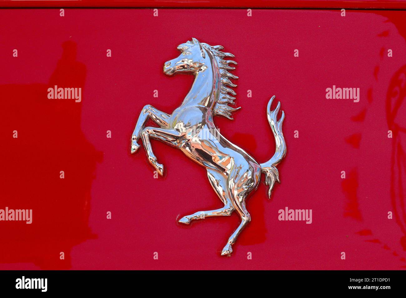 Dettaglio ravvicinato dell'iconico emblema del Cavallino rampante cromato Ferrari che adorna la carrozzeria di una delle loro sportive scarlatte. Foto Stock