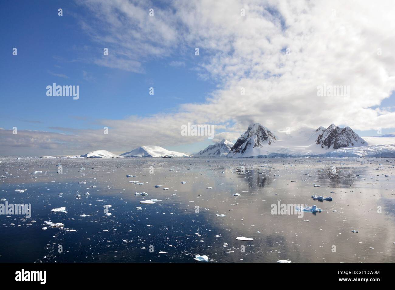 Antartide; Penisola Antartica a Yalour Island; montagne coperte di neve; ghiacciai che terminano in mare; piccole banchine di ghiaccio che si spostano al largo della costa Foto Stock