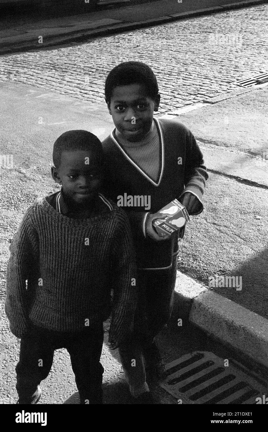 Ragazzi in una Sanderson Street acciottolata di ritorno da una commissione per lo shopping durante la slum di Victorian St Ann's, Nottingham. 1969-1972 Foto Stock