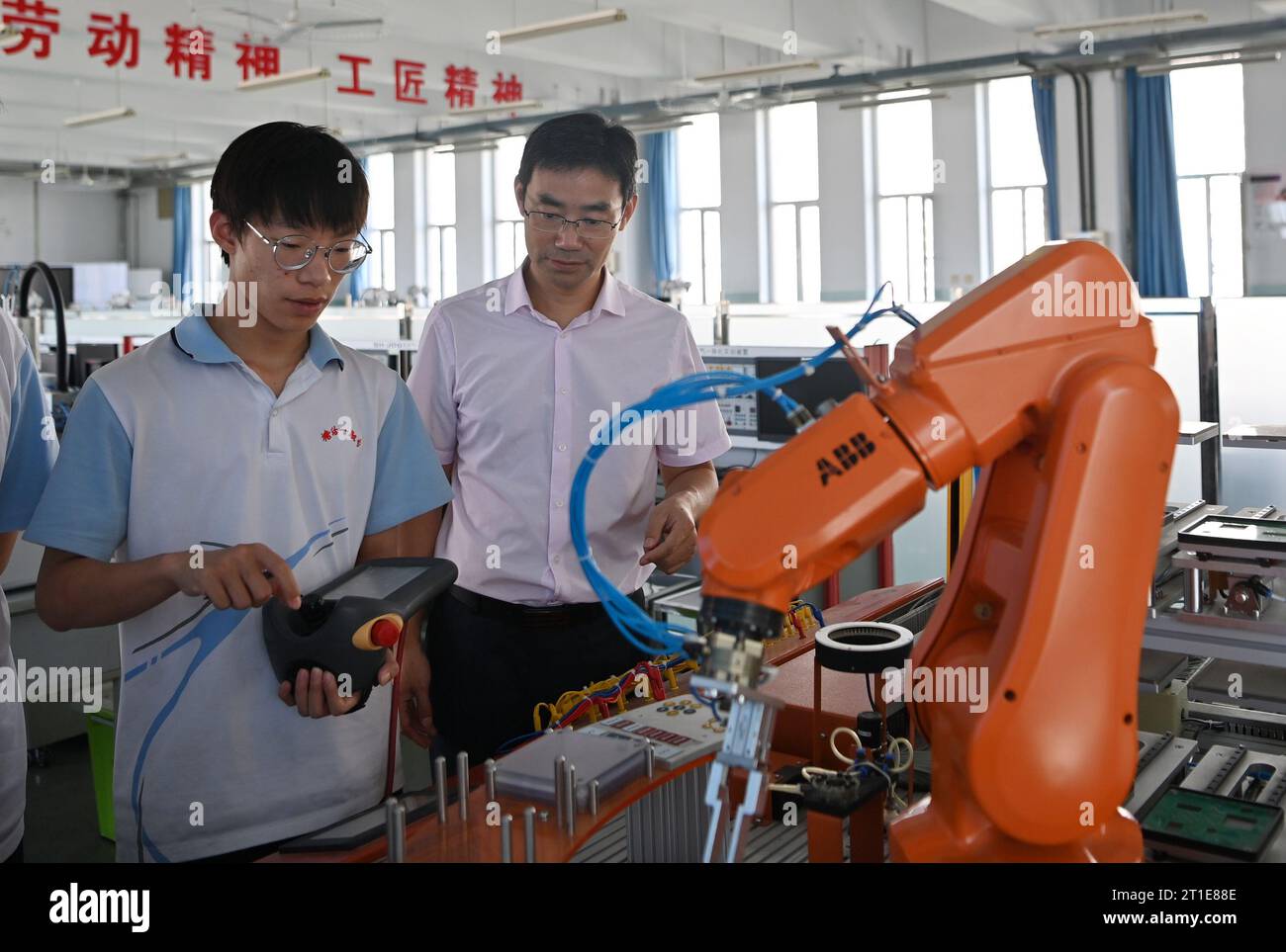 (231013) -- PECHINO, 13 ottobre 2023 (Xinhua) -- Un insegnante (R) istruisce uno studente ad usare macchine alla First Vocational School of Tanggu nel nord della Cina, Tianjin, 14 settembre 2023. Luban Workshop, inizialmente lanciato dal cinese Tianjin, è un progetto che prende il nome dall'antico artigiano cinese Lu Ban per fornire formazione professionale alle persone locali, condividendo i risultati e le risorse educative cinesi con i paesi in difficoltà. Nel marzo 2016 è stato inaugurato il primo Workshop Luban in Tailandia Ayutthaya Technical College, con una superficie di 2.000 metri quadrati e dotato di t Foto Stock