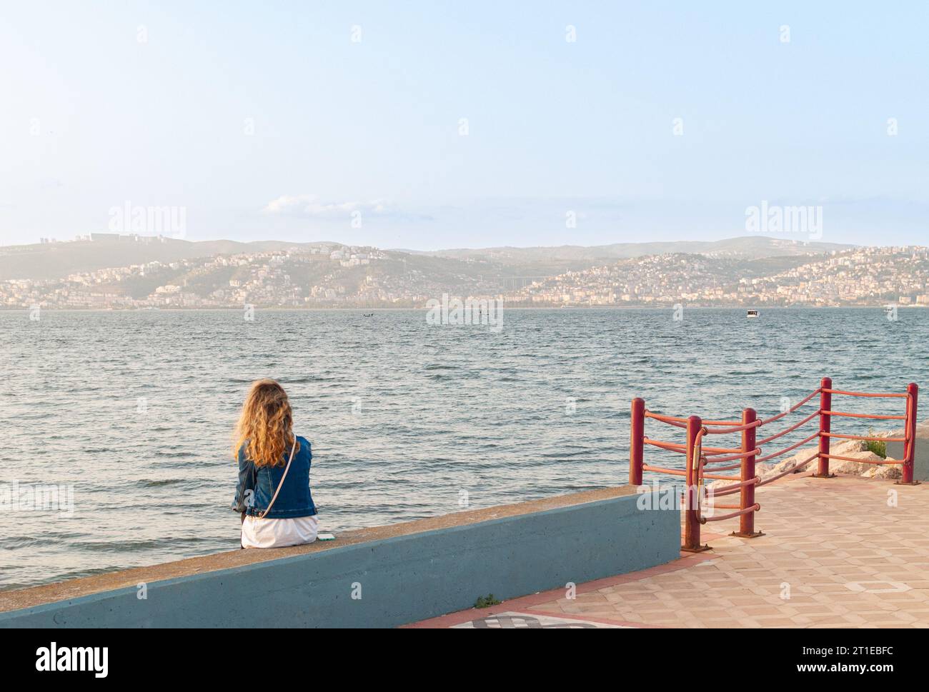 Basiskele, Kocaeli - 1 ottobre 2023: Donna bionda depressa che guarda la baia, emozioni inesplorate, naviga nel mare dei suoi pensieri Foto Stock